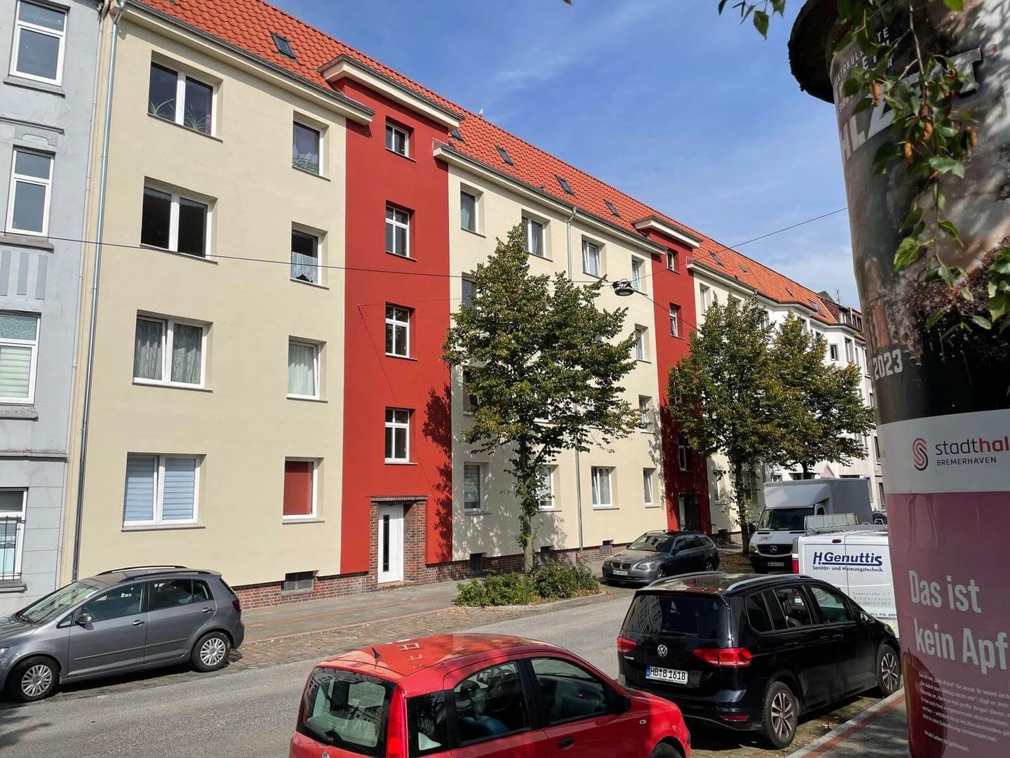 Fassadenrenovierung eines Wohnhauses mit kontrastreicher Farbgestaltung in Beige und Rot